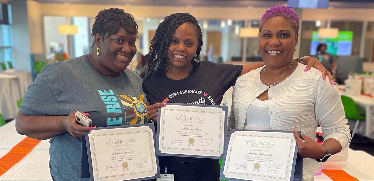 3 women holding certificates