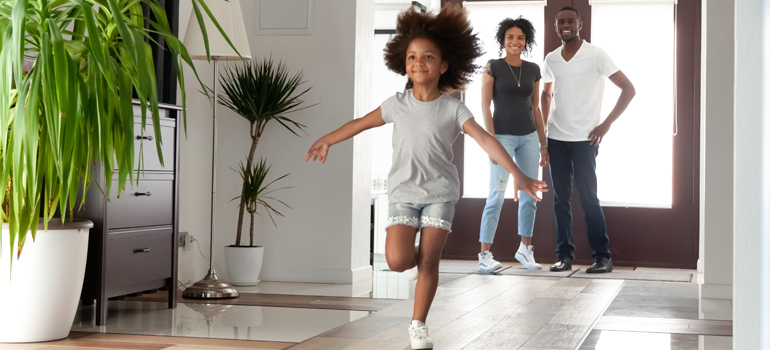 Child running into a house while others watch