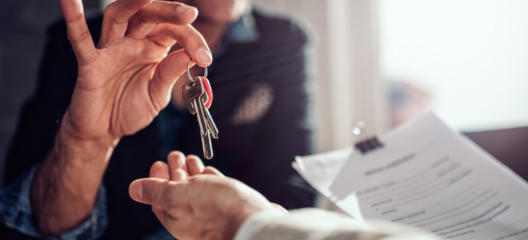 Person handing keys to another person