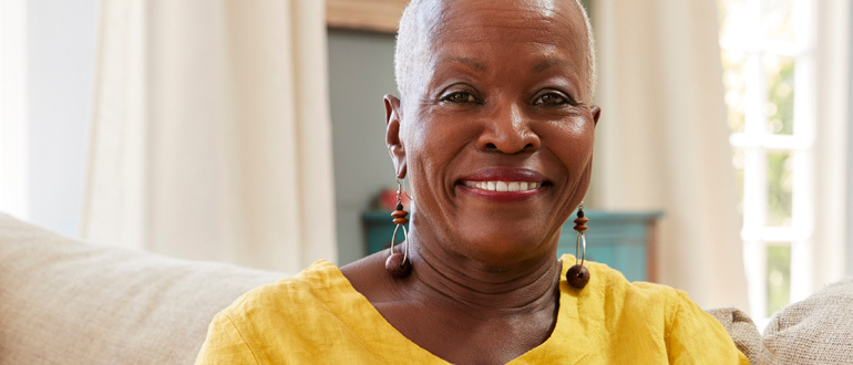 Woman sitting on a couch smiling at the camera