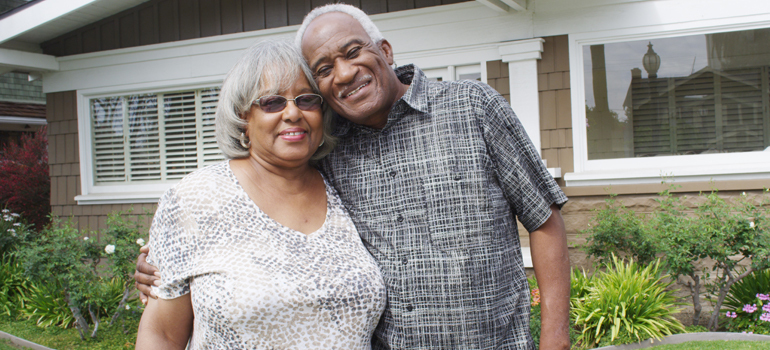 Man and woman hugging in front of a house