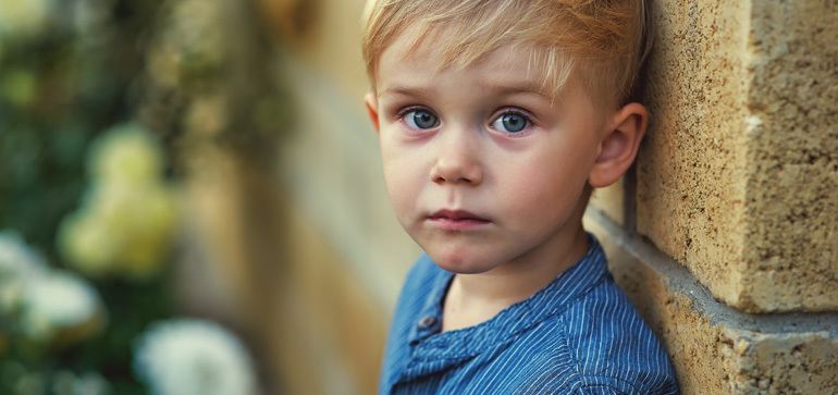 Child leaning against a wall