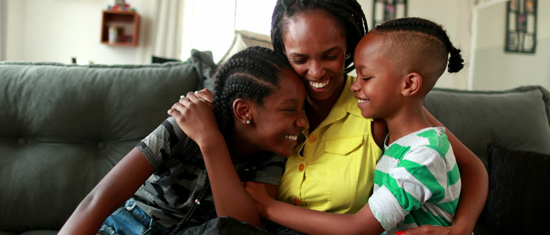 Woman hugging children on a couch
