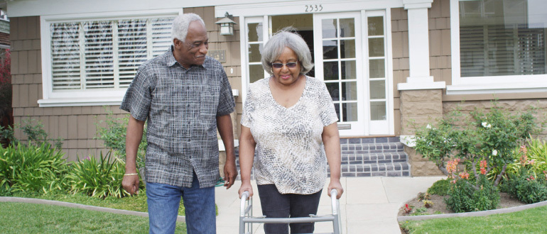 Man and woman walking out of a house