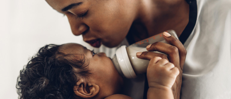 Woman bottle feeding a baby