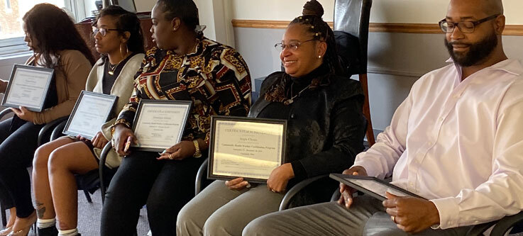 People sitting with certificates