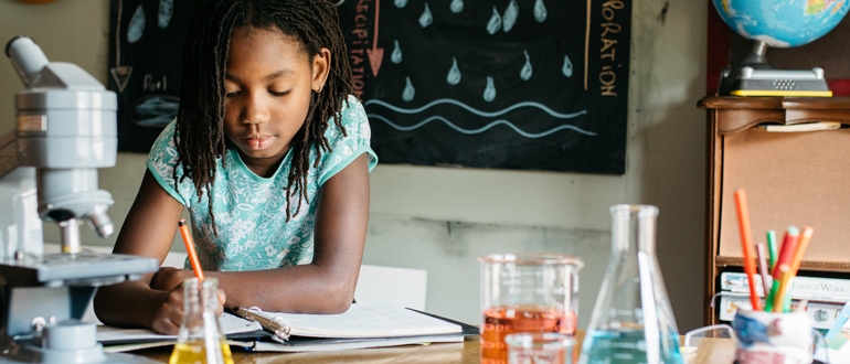 Child writing in a classroom