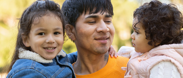 Man holding two children