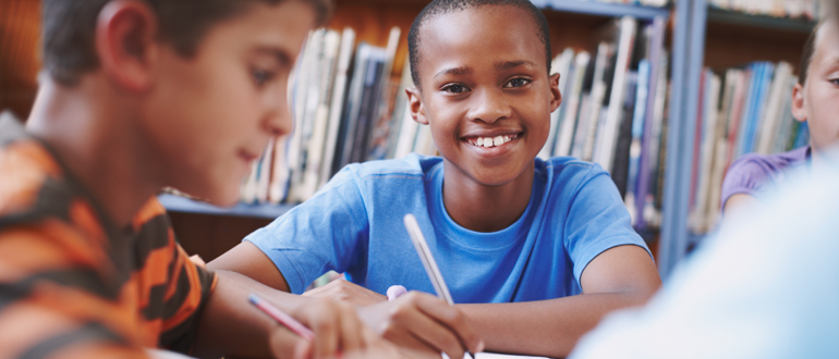 Child smiling with pencil in hand