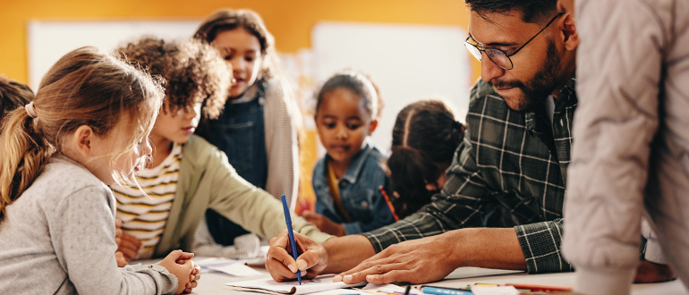 Man, writing surrounded by children