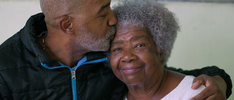 Man kissing woman on her forehead
