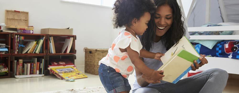 Woman reading a book with a toddler