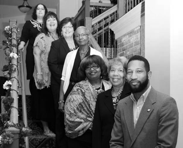 Group of people standing in a stairwell smiling
